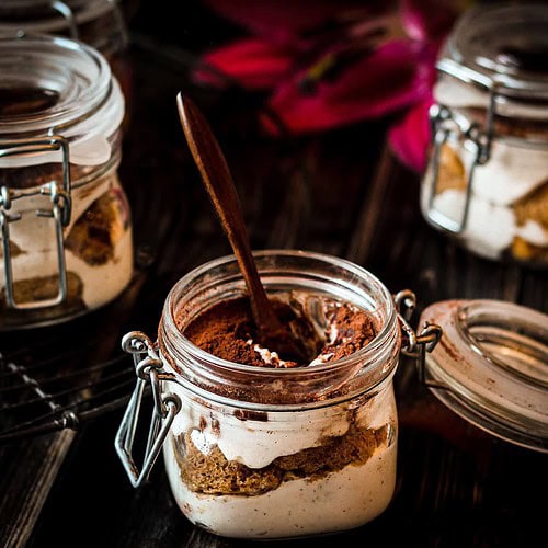 Veganes Orangen-Tiramisu im Glas mit Kakaopulver bestäubt
