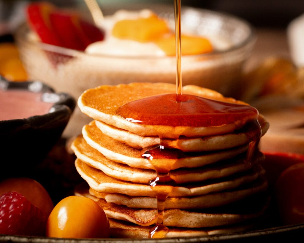 Vegan pancakes with maple syrup and fresh fruit – classic sweet treat for brunch