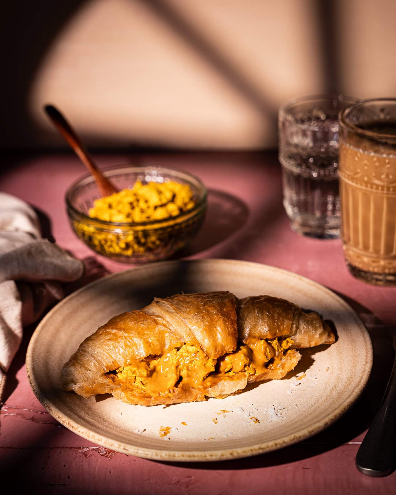 vegan croissant with tofu scramble and peanut sauce