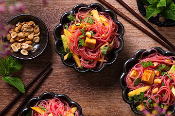 Veganer Glasnudelsalat mit Mango, Avocado und fluffigem Tofu in kleinen Schüsseln